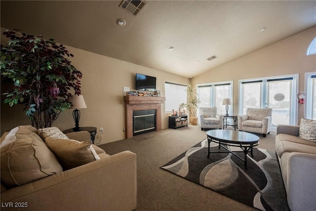 carpeted living room featuring visible vents, a glass covered fireplace, and vaulted ceiling