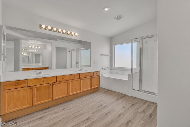 6790 Gold Yarrow St, Las Vegas, NV 89148 - full bathroom featuring a garden tub, a stall shower, double vanity, wood finished floors, and vaulted ceiling