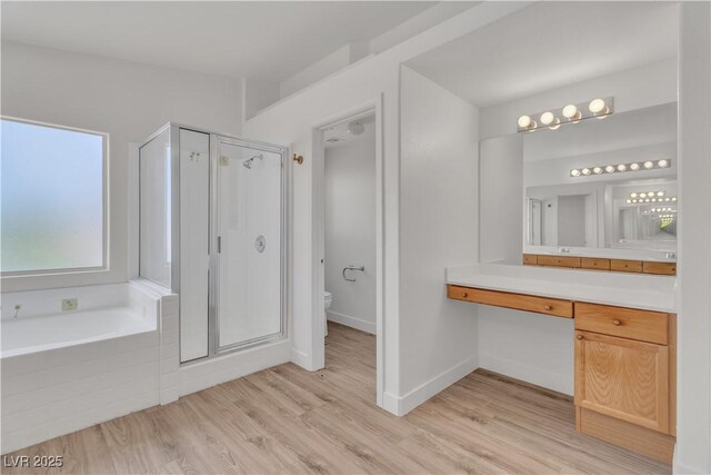 6790 Gold Yarrow St, Las Vegas, NV 89148 - bathroom with a garden tub, a stall shower, vanity, and wood finished floors
