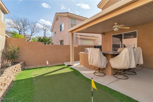 6790 Gold Yarrow St, Las Vegas, NV 89148 - fenced backyard with a putting area, a ceiling fan, and a patio