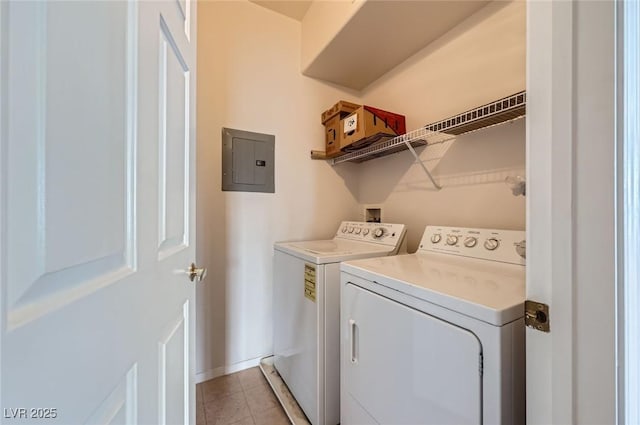washroom featuring laundry area, electric panel, baseboards, light tile patterned flooring, and washer and clothes dryer