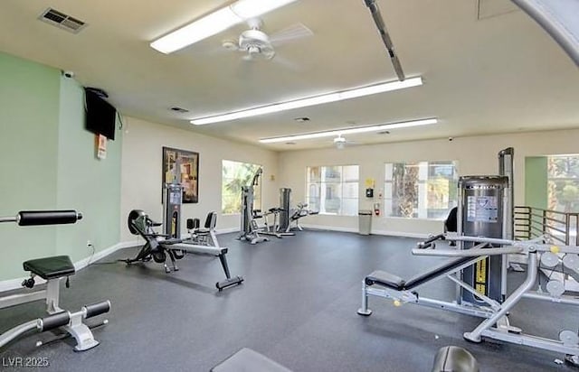 gym featuring a healthy amount of sunlight, ceiling fan, visible vents, and baseboards
