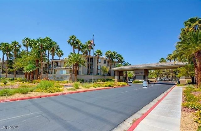 view of road with curbs, sidewalks, and a gated entry