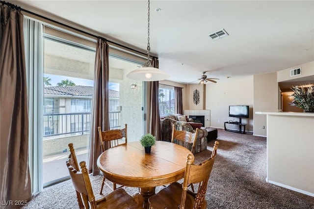 carpeted dining room with visible vents, ceiling fan, and baseboards