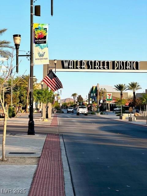 view of street featuring curbs, street lights, and sidewalks