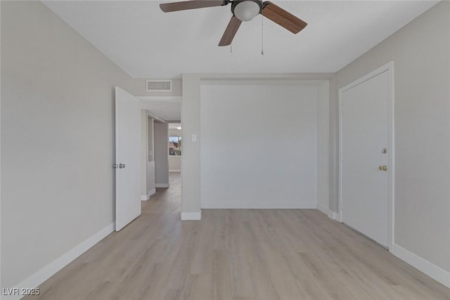 spare room with baseboards, ceiling fan, visible vents, and light wood finished floors