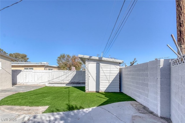 view of yard featuring a fenced backyard, a shed, an outbuilding, and a patio area