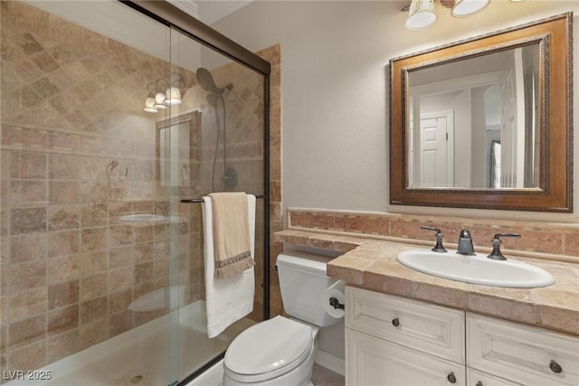 full bathroom with vanity, toilet, and a shower stall