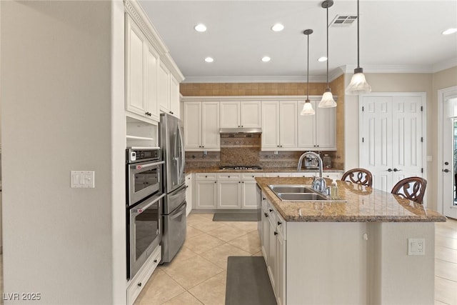 kitchen with crown molding, backsplash, a sink, stainless steel appliances, and visible vents