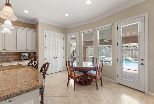 dining space featuring baseboards, ornamental molding, light tile patterned floors, and plenty of natural light