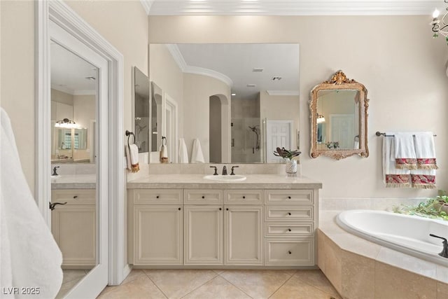 full bathroom featuring crown molding, vanity, a garden tub, a shower stall, and tile patterned flooring