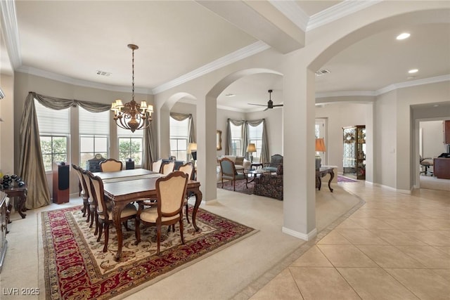dining space with a wealth of natural light, arched walkways, and light tile patterned floors