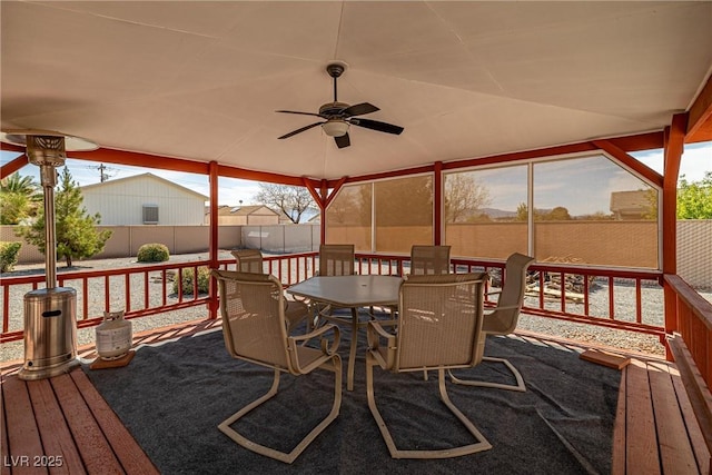 deck featuring outdoor dining space, a fenced backyard, and a ceiling fan