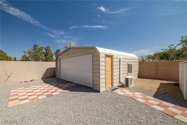 detached garage featuring central air condition unit and fence