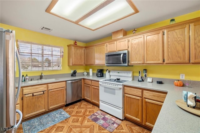 kitchen featuring stainless steel appliances, visible vents, light countertops, and a sink