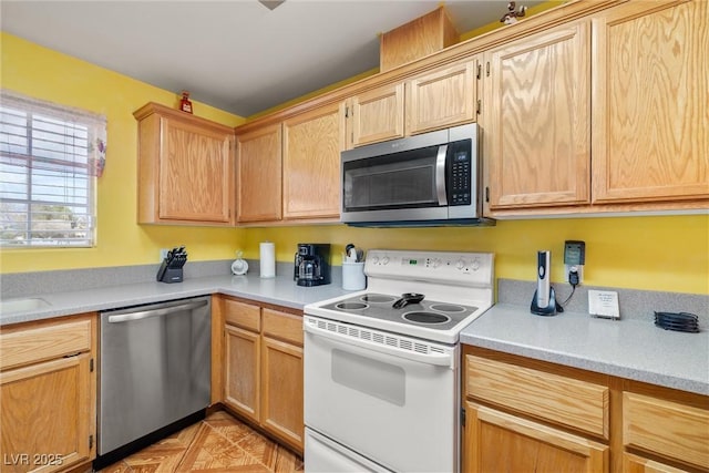 kitchen with light brown cabinets, appliances with stainless steel finishes, and light countertops
