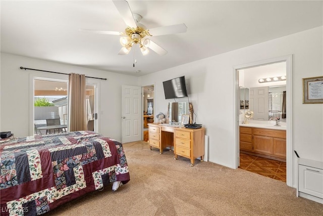 bedroom with ceiling fan, ensuite bathroom, light colored carpet, access to exterior, and a sink