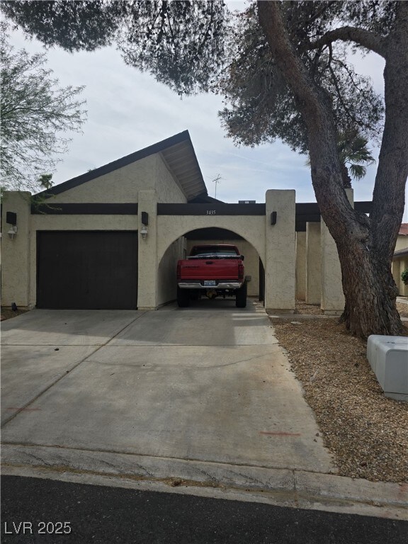 view of property exterior with a garage, driveway, and stucco siding