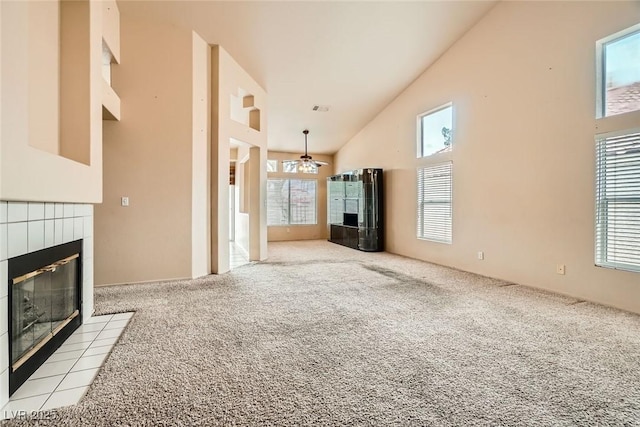 9532 Calico Garden Ave, Las Vegas, NV 89134 - unfurnished living room featuring a tile fireplace, high vaulted ceiling, and carpet flooring