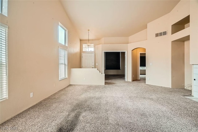 9532 Calico Garden Ave, Las Vegas, NV 89134 - unfurnished living room with high vaulted ceiling, carpet flooring, and arched walkways