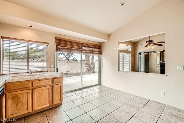 9532 Calico Garden Ave, Las Vegas, NV 89134 - kitchen with tile counters, light tile patterned floors, a sink, ceiling fan, and decorative light fixtures