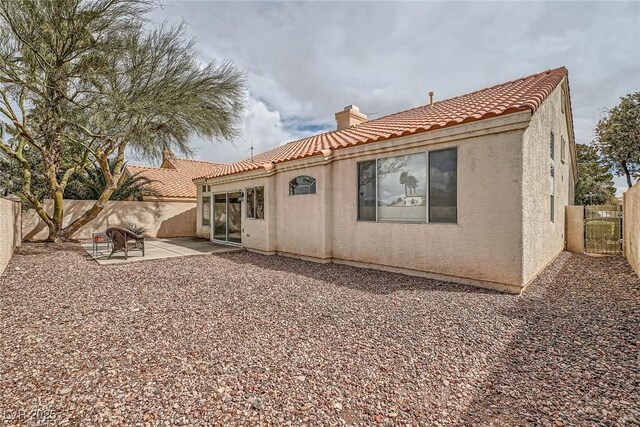9532 Calico Garden Ave, Las Vegas, NV 89134 - back of property with a tile roof, a chimney, stucco siding, a patio, and a fenced backyard