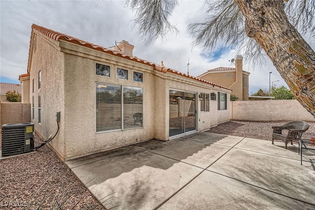 9532 Calico Garden Ave, Las Vegas, NV 89134 - rear view of house with central air condition unit, stucco siding, a patio, a chimney, and a tile roof