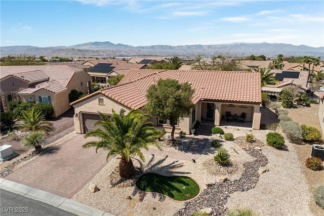 2606 Crested Butte St, Henderson, NV 89052 - mediterranean / spanish-style house with a residential view, a tile roof, a garage, stucco siding, and a mountain view