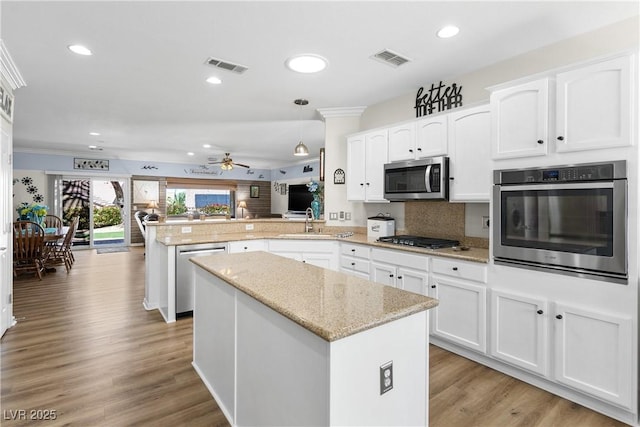 2606 Crested Butte St, Henderson, NV 89052 - kitchen featuring appliances with stainless steel finishes, ceiling fan, a peninsula, and visible vents