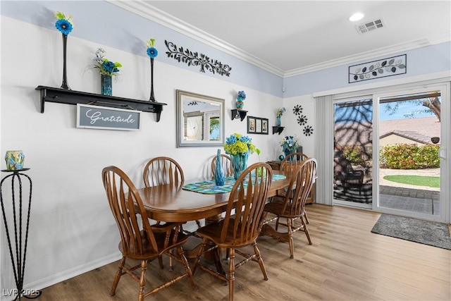 2606 Crested Butte St, Henderson, NV 89052 - dining space featuring visible vents, ornamental molding, baseboards, and wood finished floors