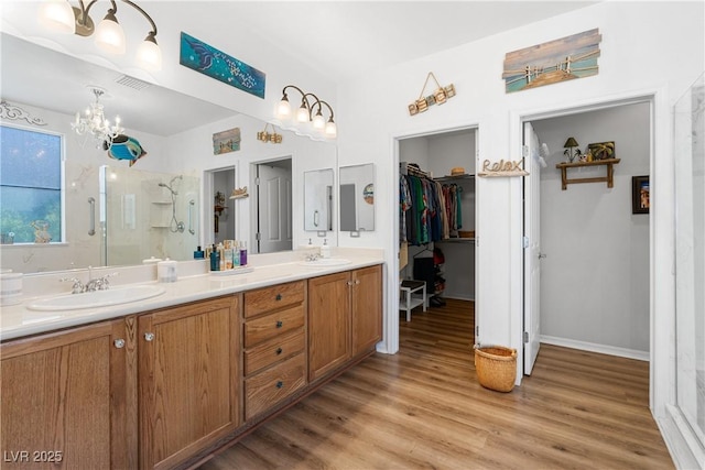 2606 Crested Butte St, Henderson, NV 89052 - bathroom with a sink, wood finished floors, a chandelier, and a shower stall