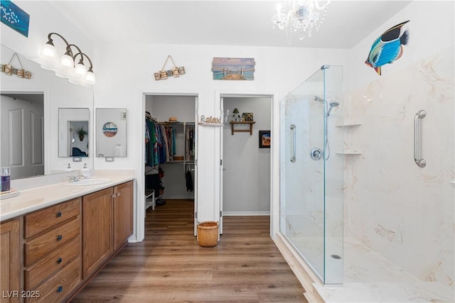 2606 Crested Butte St, Henderson, NV 89052 - full bathroom featuring an inviting chandelier, a marble finish shower, wood finished floors, and vanity
