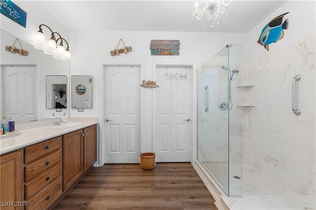 2606 Crested Butte St, Henderson, NV 89052 - full bath with an inviting chandelier, a marble finish shower, vanity, and wood finished floors