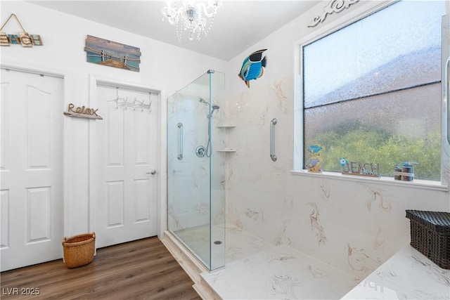 2606 Crested Butte St, Henderson, NV 89052 - bathroom with an inviting chandelier, a marble finish shower, and wood finished floors