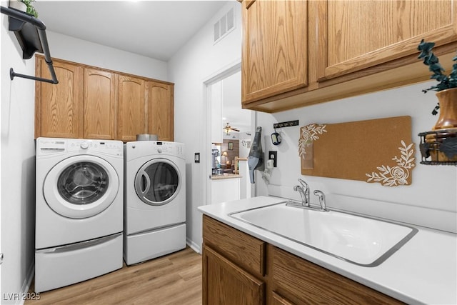 2606 Crested Butte St, Henderson, NV 89052 - laundry room with cabinet space, washer and dryer, a sink, light wood finished floors, and visible vents