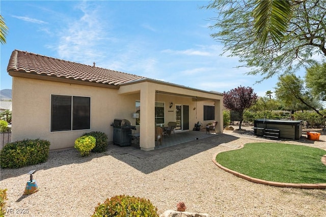 2606 Crested Butte St, Henderson, NV 89052 - rear view of house featuring a hot tub, a tiled roof, a patio area, and stucco siding