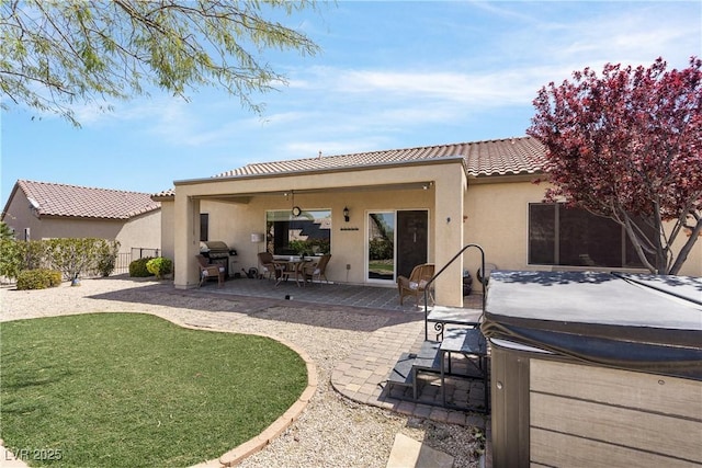 2606 Crested Butte St, Henderson, NV 89052 - back of property featuring fence, a hot tub, stucco siding, a patio area, and a tiled roof
