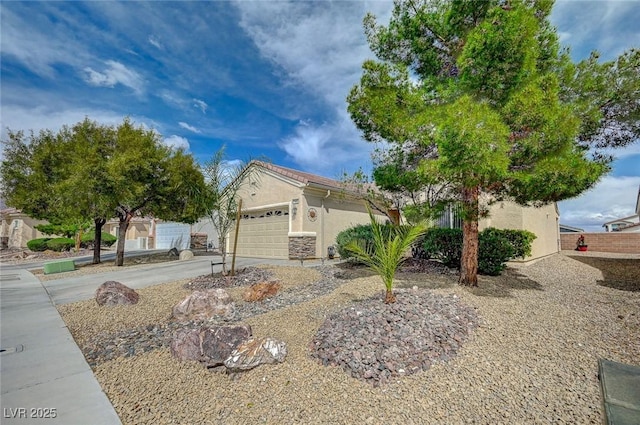 7460 Chaffinch St, North Las Vegas, NV 89084 - view of property hidden behind natural elements featuring stucco siding, an attached garage, and driveway