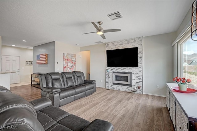 7460 Chaffinch St, North Las Vegas, NV 89084 - living room featuring wood finished floors, a ceiling fan, baseboards, and a fireplace