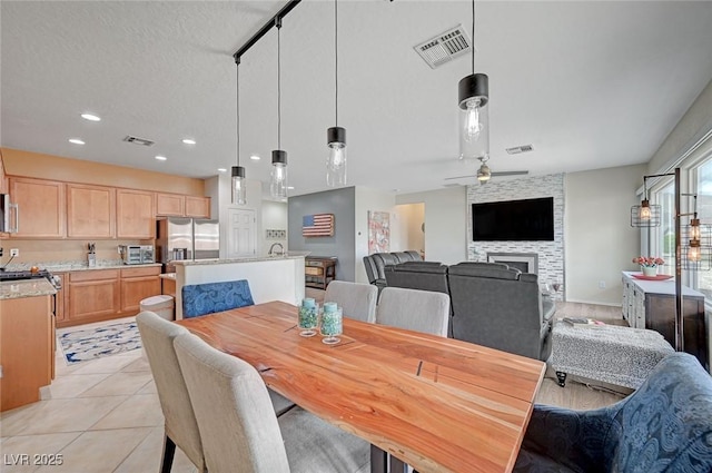 7460 Chaffinch St, North Las Vegas, NV 89084 - dining room featuring a fireplace, a ceiling fan, light tile patterned floors, and recessed lighting