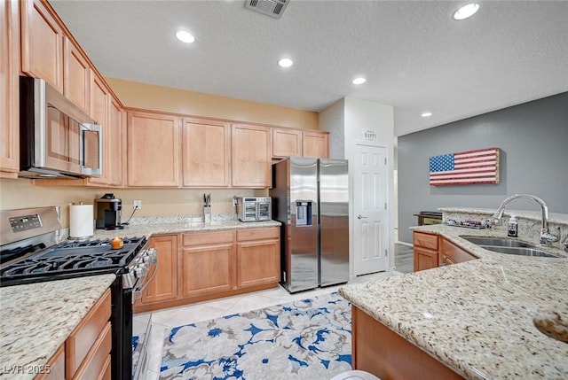 7460 Chaffinch St, North Las Vegas, NV 89084 - kitchen featuring stainless steel appliances, a sink, recessed lighting, light brown cabinetry, and light stone counters