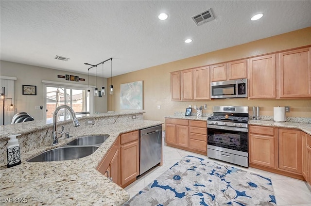 7460 Chaffinch St, North Las Vegas, NV 89084 - kitchen featuring stainless steel appliances, a sink, light brown cabinetry, light tile patterned floors, and light stone counters