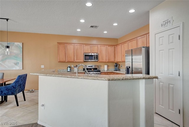 7460 Chaffinch St, North Las Vegas, NV 89084 - kitchen featuring stainless steel appliances, light brown cabinetry, light stone counters, light tile patterned floors, and recessed lighting