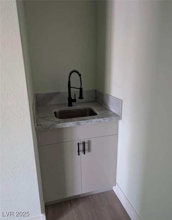 bar featuring dark wood-style flooring and a sink