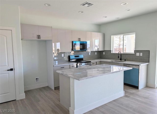 kitchen with visible vents, a sink, black microwave, dishwashing machine, and electric range