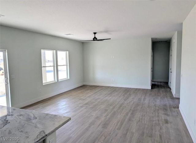 unfurnished living room with baseboards, visible vents, light wood-style flooring, and a ceiling fan