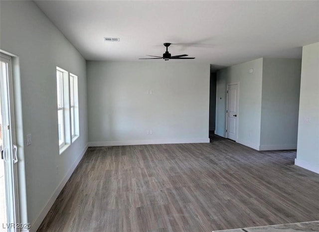 interior space with baseboards, ceiling fan, visible vents, and wood finished floors
