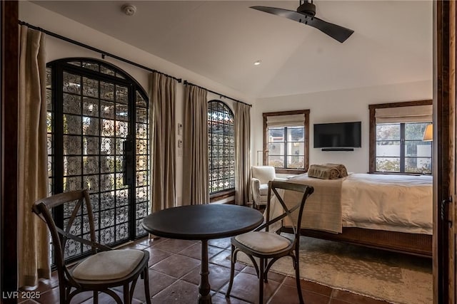 tiled bedroom with lofted ceiling and a ceiling fan