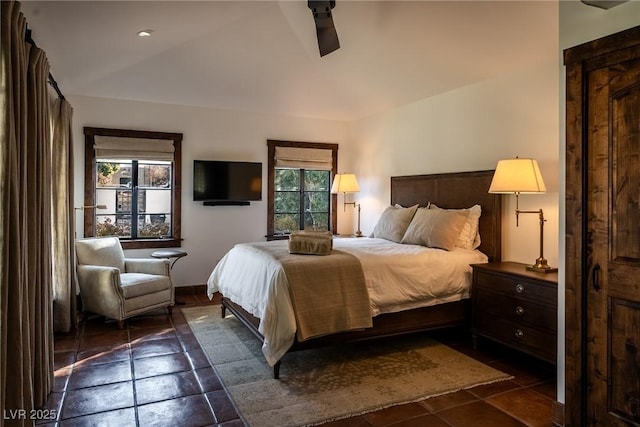 bedroom featuring dark tile patterned floors, a ceiling fan, and lofted ceiling
