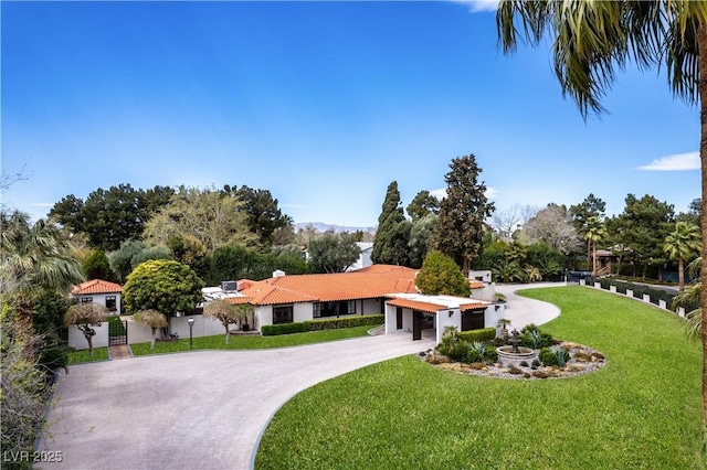 view of front of property featuring curved driveway, a tiled roof, and an attached carport